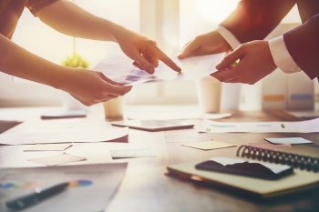 Vier Hände, die Arbeitspapiere halten